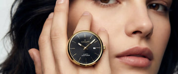 Frau trägt am Finger eine Cichart Ringuhr mit schwarzem Zifferblatt