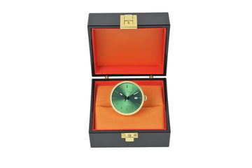 Grüne Zifferblatt-Uhr mit goldfarbenem Gehäuse und Lunette, präsentiert in einer schwarzen Box mit orangefarbenem Samt-Futter.