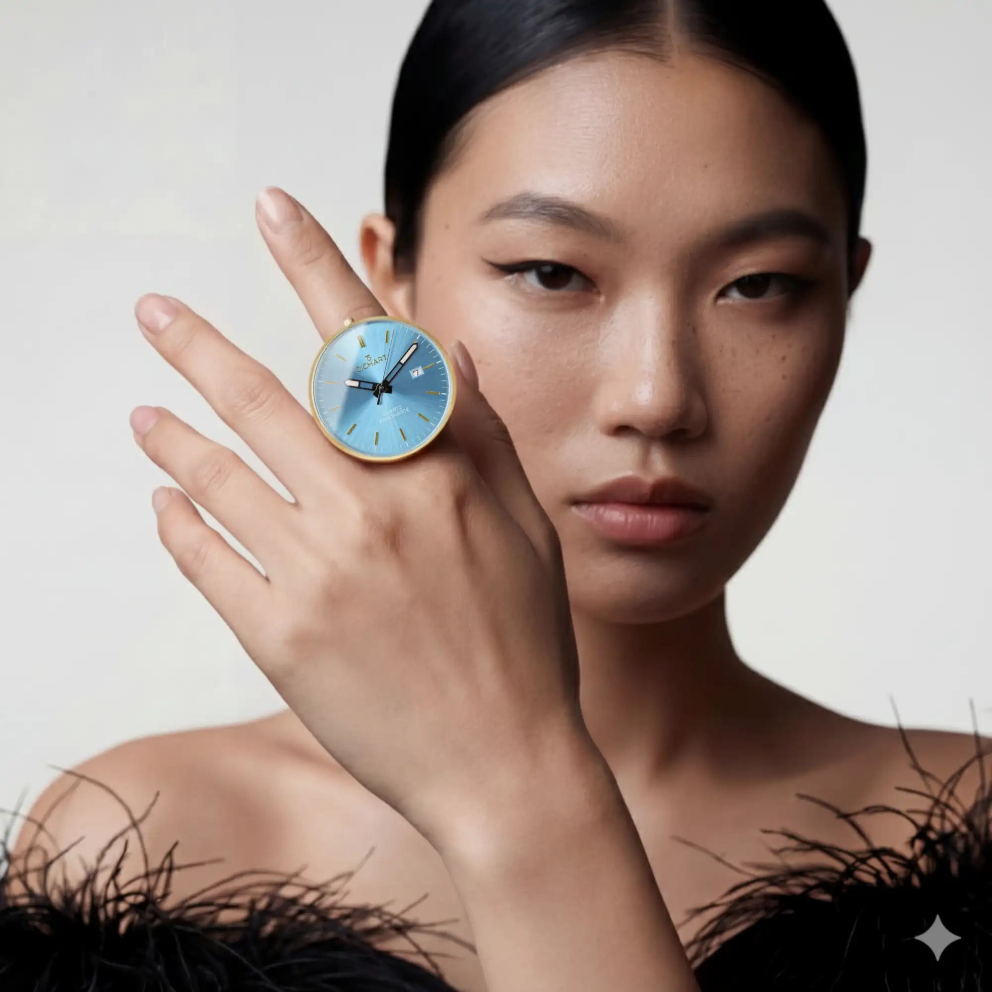 Ein zarter Ring in Goldton mit einem runden blauen Zifferblatt und minimalistischen Stundeneinteilungen, gestaltet, um eine elegante Taschenuhr nachzuahmen.